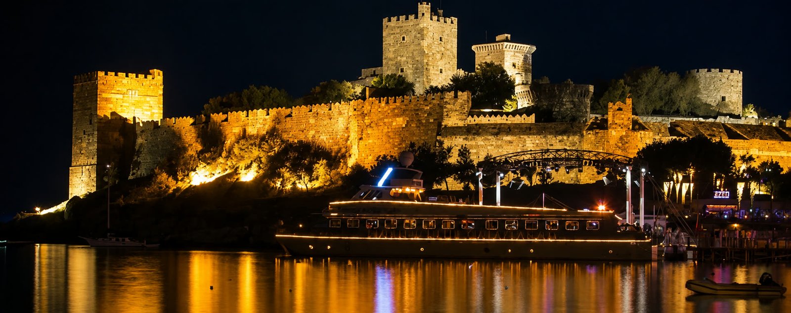 Bodrum Kalesi gece, aydınlatılmış surlar ve limanın suyundaki yansımaları